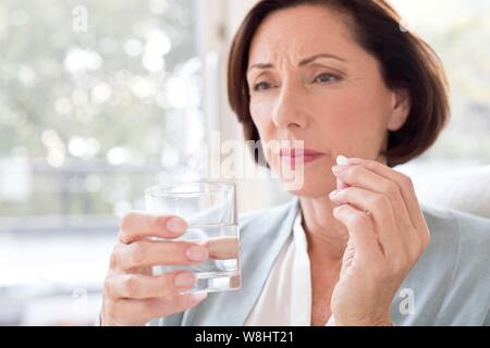 Mature woman taking tablet. Stock Photo