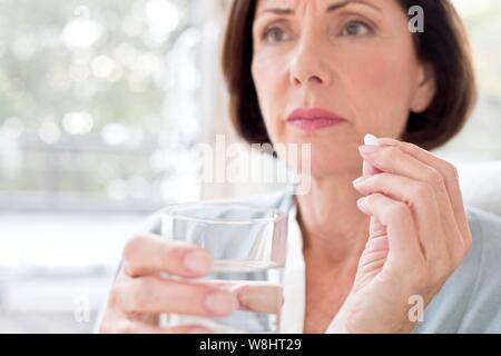 Mature woman taking tablet. Stock Photo