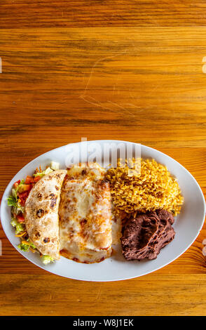 Chicken Enchilada plate with rice, beans and chicken taco Stock Photo