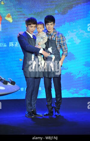 Chinese actors Zhang Yixing, left, and Chen Xuedong pose with a little baby at a press conference for their new movie 'Oh My God' in Beijing, China, 4 Stock Photo