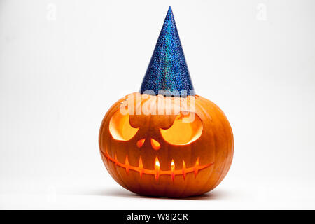 Halloween pumpkin head jack lantern with burning candles with festive hubcap isolated on white background Stock Photo