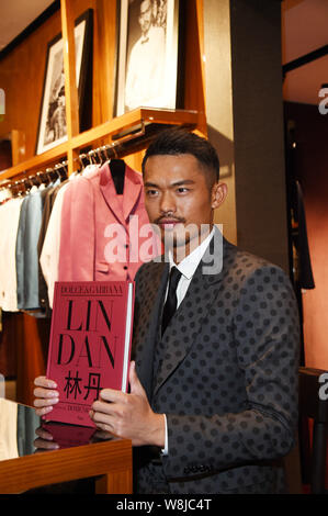 Chinese badminton star Lin Dan poses with his photo album at a signing event in Beijing, China, 20 March 2015. Stock Photo