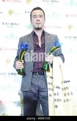 Chinese singer Yang Kun poses with his trophies during the 22th Oriental Billboard Awards ceremony in Shanghai, China, 30 March 2015. Stock Photo