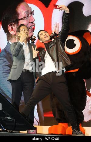 Taiwanese singer Jam Hsiao, right, takes selfies with an Asus ZenFone2 smartphone at a promotional event in Taipei, Taiwan, 9 March 2015. Stock Photo