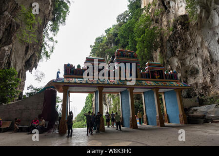 Kuala Lumpur, Malaysia - September 7, 2018: Entrance of Batu Cave and tourists seen exploring and praying in the Hindu Temple, Batu Caves, Malaysia. - Stock Photo