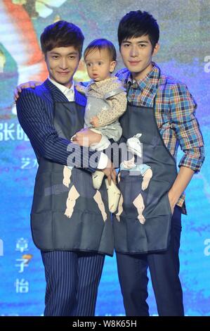 Chinese actors Zhang Yixing, left, and Chen Xuedong pose with a little baby at a press conference for their new movie 'Oh My God' in Beijing, China, 4 Stock Photo