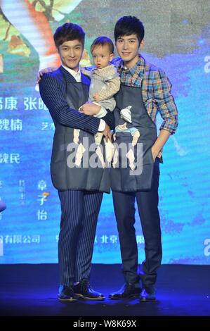 Chinese actors Zhang Yixing, left, and Chen Xuedong pose with a little baby at a press conference for their new movie 'Oh My God' in Beijing, China, 4 Stock Photo