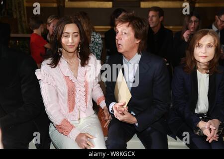 Former Beatle Sir Paul McCartney, center, and his wife Nancy Shevell, left, attend the fashion show of his daughter Stella McCartney during the Paris Stock Photo