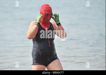 A Chinese woman wearing a facekini walks at a beach resort in Qingdao city,  east China's Shandong province, 5 July 2016. Summer is here! With temper  Stock Photo - Alamy