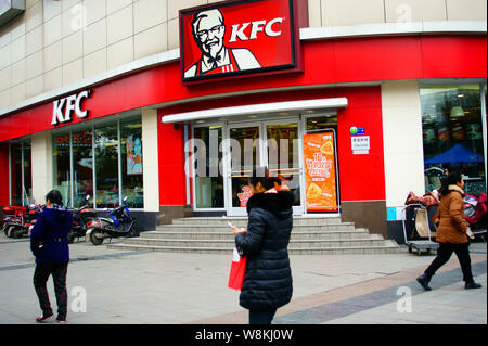 --FILE--Pedestrians walk past a fastfood restaurant of KFC in Yichang city, central China's Hubei province, 13 January 2016.    One of Chinas largest Stock Photo