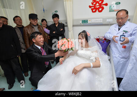 Terminally ill Chinese woman Yang Liu dressed in a wedding gown, second right, receives a wedding proposal from her husband Peng Xin, third right, dur Stock Photo