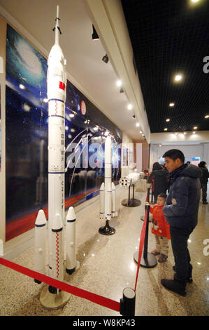 --FILE--Chinese visitors look at models of China's Long March-series carrier rockets on display during an exhibition in Haining city, east China's Zhe Stock Photo