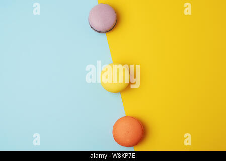 multi-colored baked round macarons on a colored background, flat lay Stock Photo