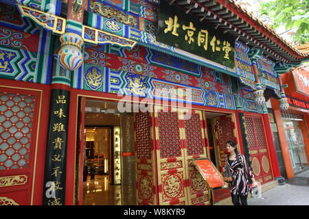 --FILE--A pedestrian walks past a branch of Beijing Tongrentang, a time-honored Traditional Chinese Medicine brand since 1669, in Shanghai, China, 22 Stock Photo