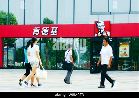 --FILE--Pedestrians walk past a fastfood restaurant of KFC in Yichang city, central China's Hubei province, 25 August 2015.   Three technology compani Stock Photo