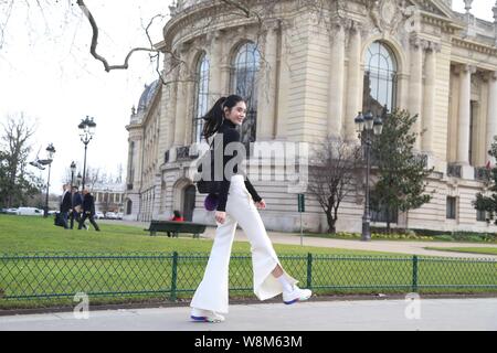 Chinese model Xi Mengyao poses for street snap after the Chanel fashion show during the Paris Haute Couture Fashion Week Spring/Summer 2016 in Paris, Stock Photo