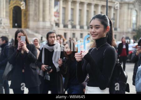 Chinese model Xi Mengyao poses for street snap after the Chanel fashion show during the Paris Haute Couture Fashion Week Spring/Summer 2016 in Paris, Stock Photo