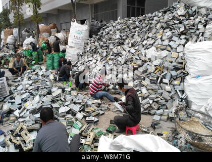 Chinese workers remove components from hard drives of computers at a factory in Guiyu town, Shantou city, south China's Guangdong province, 26 Decembe Stock Photo