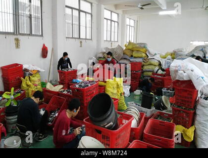 Chinese workers remove components from circuit boards of mobile phones at a factory in Guiyu town, Shantou city, south China's Guangdong province, 26 Stock Photo