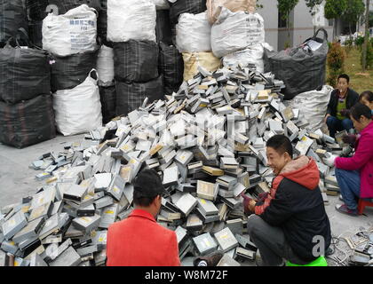 Chinese workers remove components from hard drives of computers at a factory in Guiyu town, Shantou city, south China's Guangdong province, 26 Decembe Stock Photo