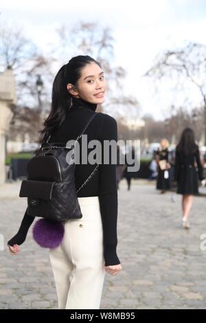 Chinese model Xi Mengyao poses for street snap after the Chanel fashion show during the Paris Haute Couture Fashion Week Spring/Summer 2016 in Paris, Stock Photo