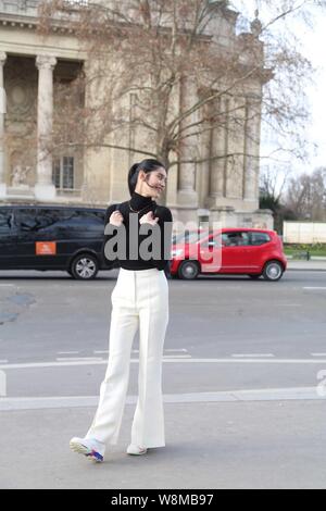 Chinese model Xi Mengyao poses for street snap after the Chanel fashion show during the Paris Haute Couture Fashion Week Spring/Summer 2016 in Paris, Stock Photo