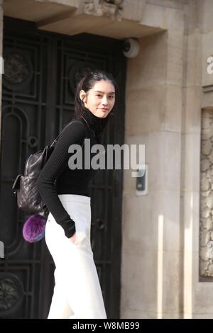 Chinese model Xi Mengyao poses for street snap after the Chanel fashion show during the Paris Haute Couture Fashion Week Spring/Summer 2016 in Paris, Stock Photo