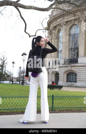 Chinese model Xi Mengyao poses for street snap after the Chanel fashion show during the Paris Haute Couture Fashion Week Spring/Summer 2016 in Paris, Stock Photo