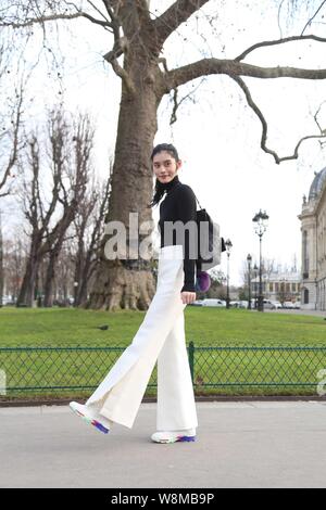 Chinese model Xi Mengyao poses for street snap after the Chanel fashion show during the Paris Haute Couture Fashion Week Spring/Summer 2016 in Paris, Stock Photo