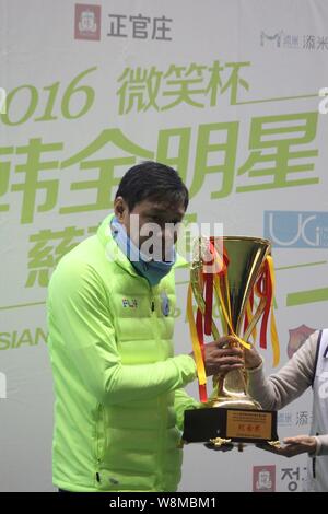 Chinese soccer star Fan Zhiyi receives a trophy after the '2016 Asian Smile Cup in China' friendly football match in Shanghai, China, 10 January 2016. Stock Photo