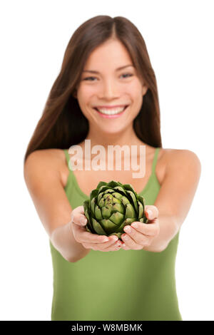 Woman holding fresh artichoke globe flower closeup isolated on white background. Asian happy girl showing green vegetable ingredient for cooking in cupped hands. Artichokes healthy diet concept. Stock Photo
