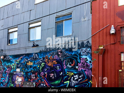 Los Angeles, CA / USA - April 12 2019: Vibrant street art mural covers entrance to a renovated industrial building in the gentrified Arts District. Stock Photo