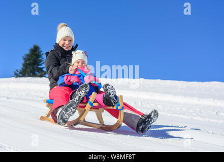 Funny afternoon in wintertime on sleigh slope Stock Photo