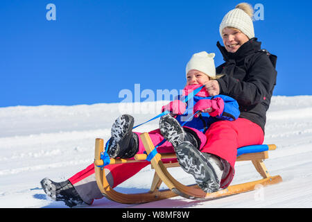 Funny afternoon in wintertime on sleigh slope Stock Photo