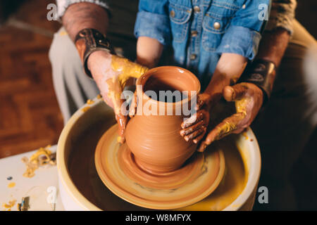 Pottery workshop. Grandpa teaches granddaughter pottery. Clay modeling Stock Photo