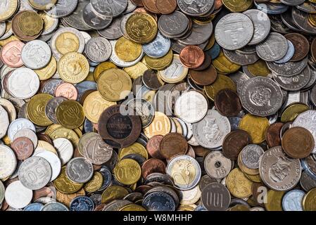 Coins in colour, international collection. Coin background. Stock Photo