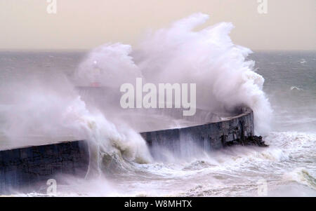 Newhaven, East Sussex, UK. 10th August 2019. Strong winds along the south coasy bring huge waves to Newhaven harbour, dwarfing the Victorian cast iron lighthouse. © Peter Cripps/Alamy Live News Stock Photo