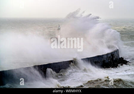 Newhaven, East Sussex, UK. 10th August 2019. Strong winds along the south coasy bring huge waves to Newhaven harbour, dwarfing the Victorian cast iron lighthouse. © Peter Cripps/Alamy Live News Stock Photo