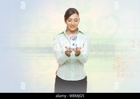 Businesswoman holding an hourglass Stock Photo