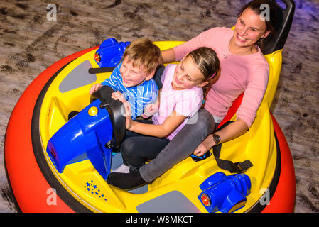 Scooter driving with the kids in indoor playground Stock Photo