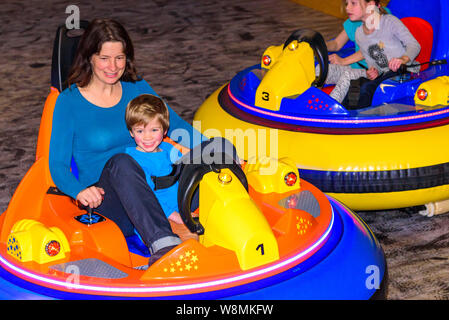 Scooter driving with the kids in indoor playground Stock Photo