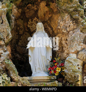 Statue of Our Lady of Lourdes in the Grotto in the grounds of Château de Sully in the Loire Valley, France Stock Photo