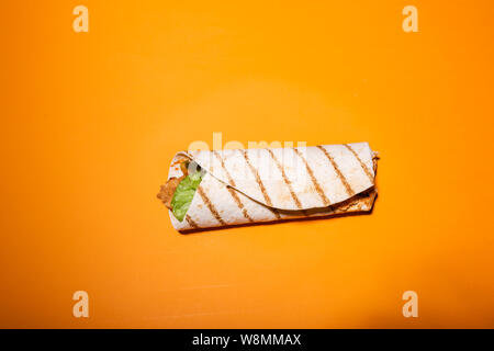 Flat lay photo of tortilla isolated on orange background Stock Photo
