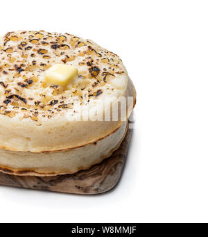 Giant  crumpets with melted butter on cutting board isolated on white Stock Photo