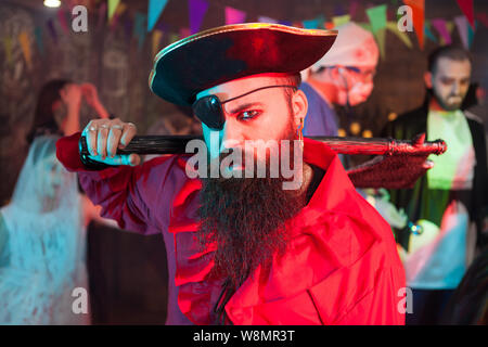 Side view portrait of handsome bearded man in a pirate costume at halloween celebration. Attractive man in a pirate costume. Stock Photo