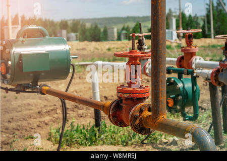 Oil and gas processing plant with pipe line valves. Oil pipeline valves in the oil and gas industry. Valve plug an oil pipeline in the field on a sunn Stock Photo