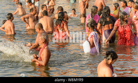 Indian pilgrims perform early morning bathing rituals in the River Ganges in Varanasi, Uttar Pradesh, India, South Asia. Stock Photo