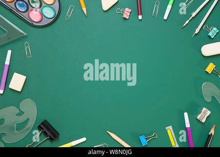 School supplies on green chalkboard  background - top view Stock Photo
