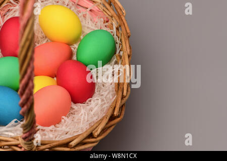 Left a basket of colored Easter eggs on the right a blank space for the label, copyspace. Horizontal photography Stock Photo
