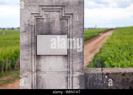 Closeup vintage rectangular shape stone aged plate, nameboard on gray textured wall. Concept place for lettering, text, copyspace Stock Photo